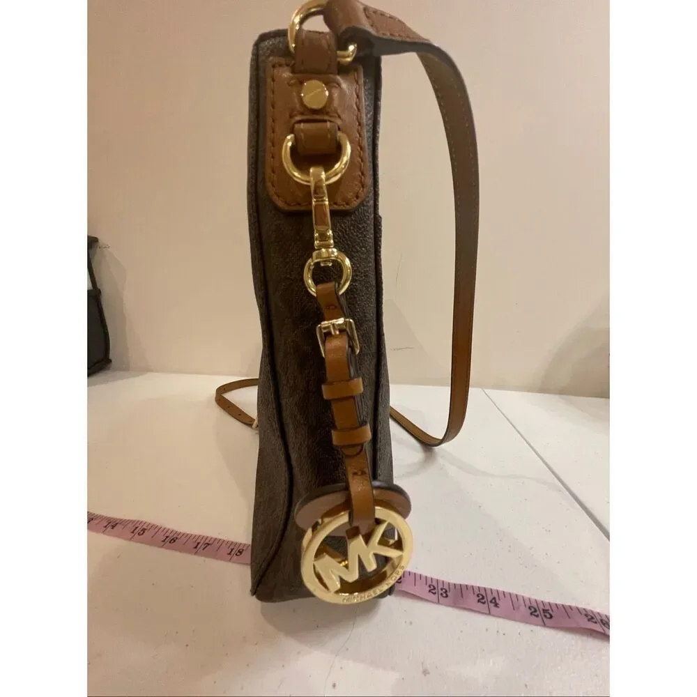 a Michael Kors Jet Set Travel Large Messenger Bag, featuring the brand's signatu